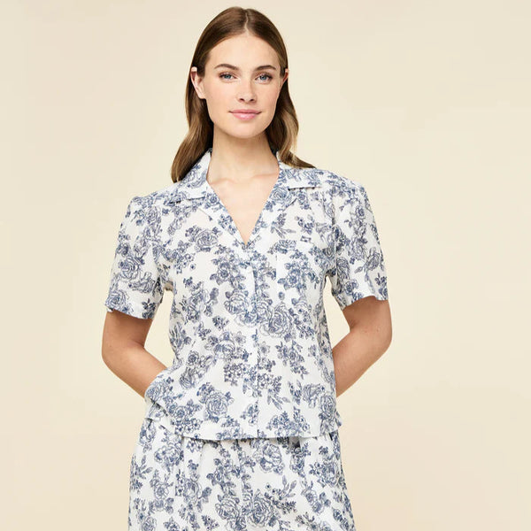 Woman wearing a floral pajama set on a beige background
