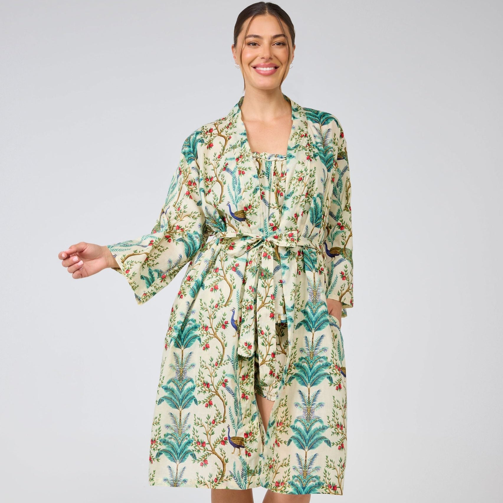 Woman wearing a floral patterned robe on a plain background