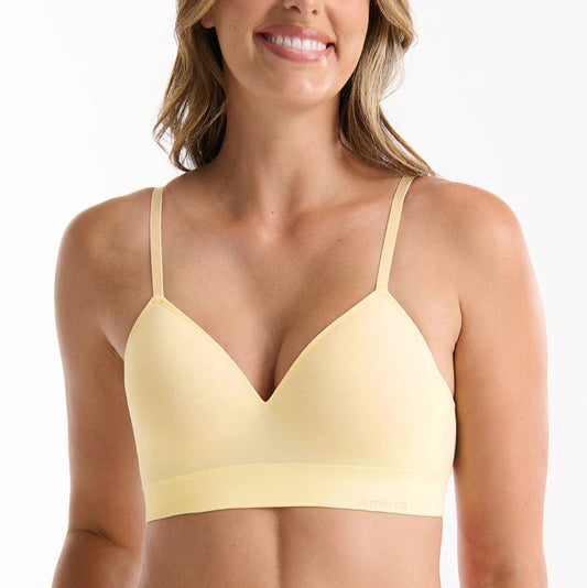 Woman wearing a yellow bra and underwear set on a white background