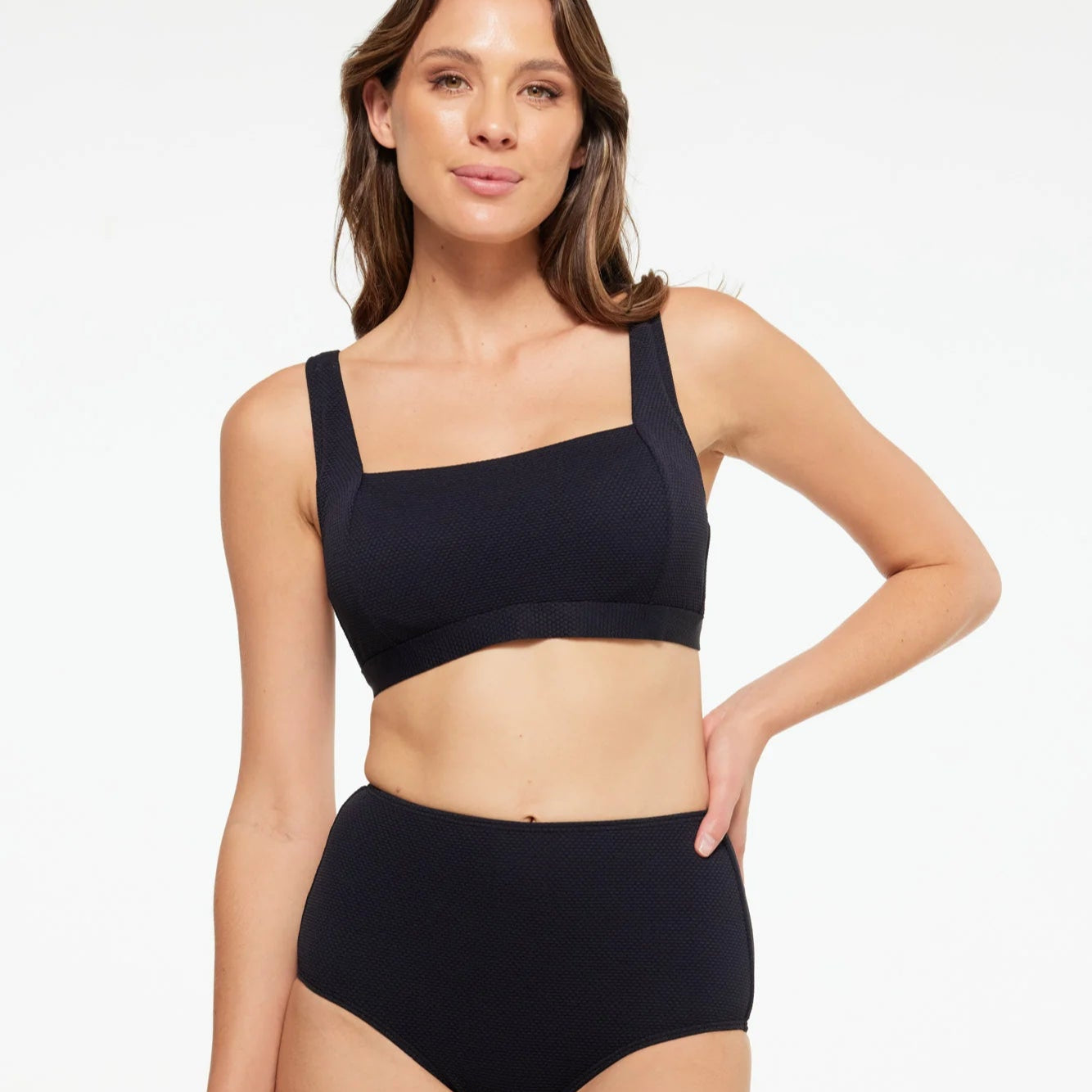 Woman wearing a black bikini set on a white background