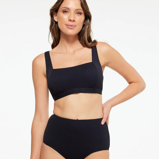 Woman wearing a black bikini set on a white background