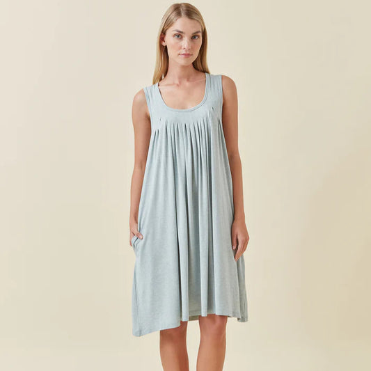 Woman wearing a light blue sleeveless dress on a beige background
