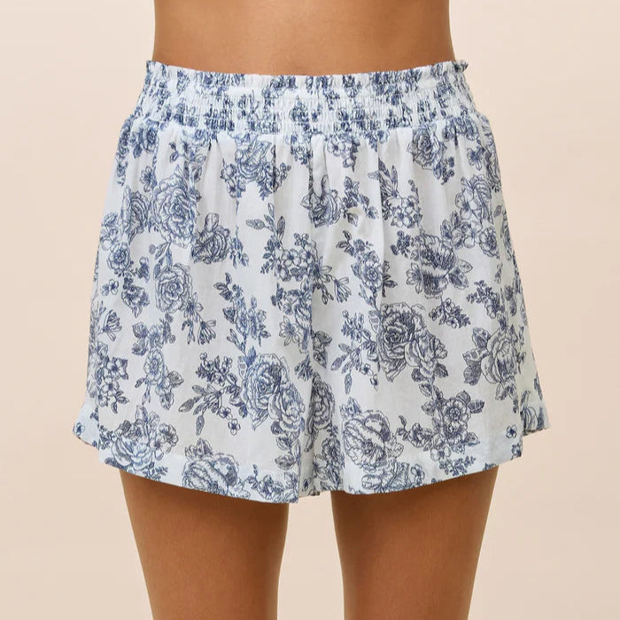 Floral shorts worn by a person on a beige background