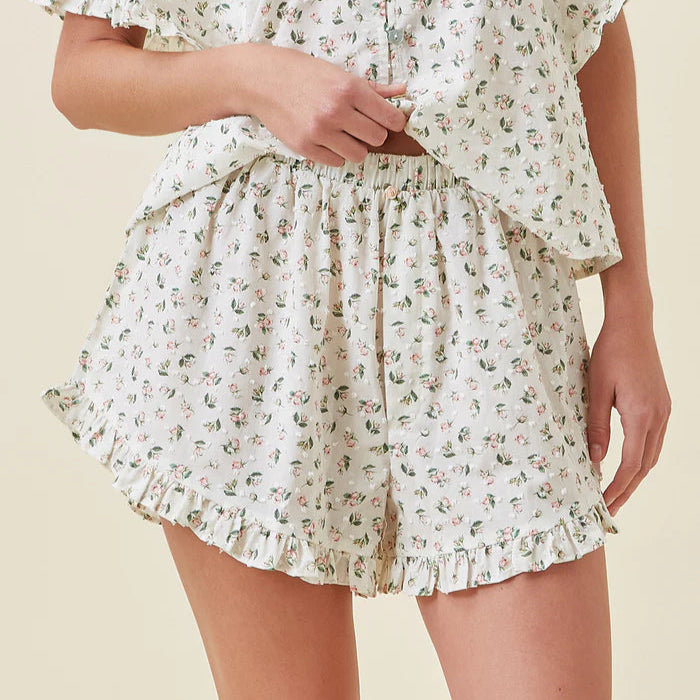 Floral patterned shorts worn by a person on a beige background