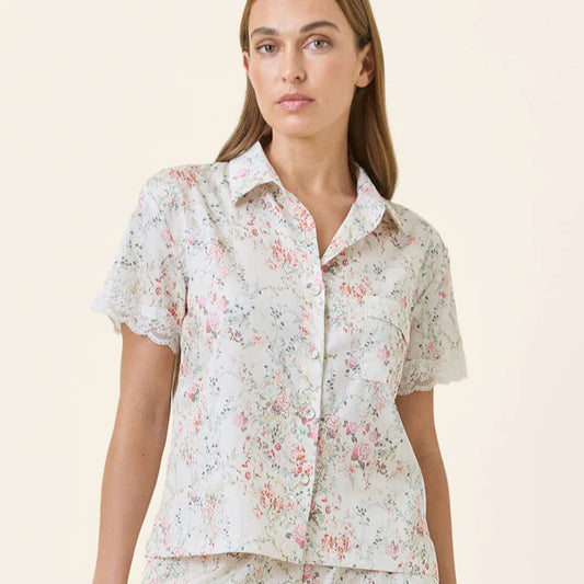 Woman wearing a floral pajama set on a beige background