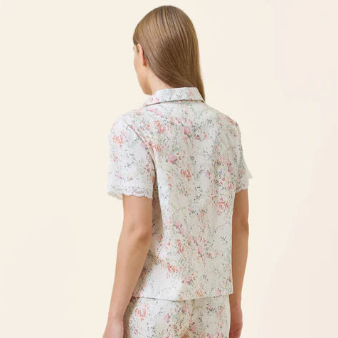 Woman wearing a floral pajama set on a beige background