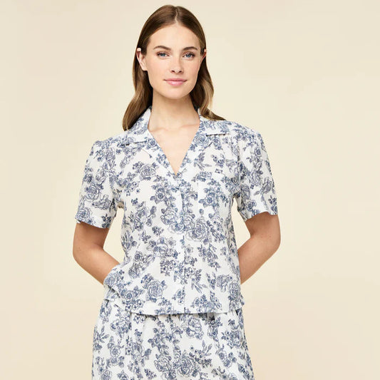 Woman wearing a floral pajama set on a beige background