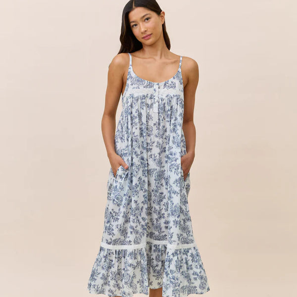 Woman wearing a blue floral dress on a beige background