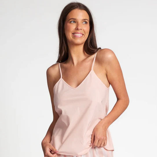 Woman wearing a light pink slip and shorts set on a white background