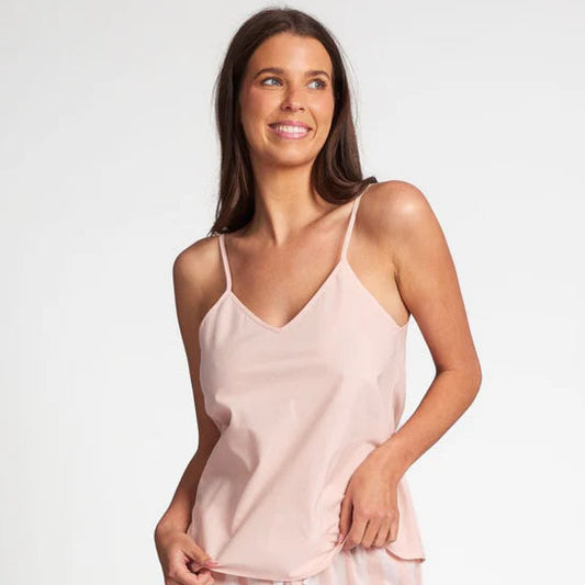 Woman wearing a light pink slip and shorts set on a white background