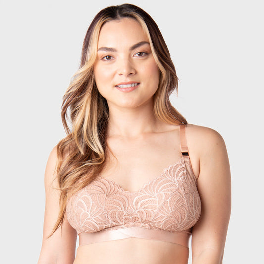 Woman wearing a pink lace bra against a plain background