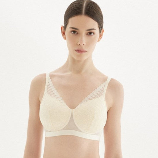 Woman wearing a beige bra and panties set on a white background