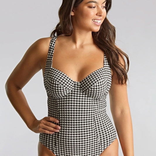 Woman wearing a black and white checkered swimsuit on a gray background