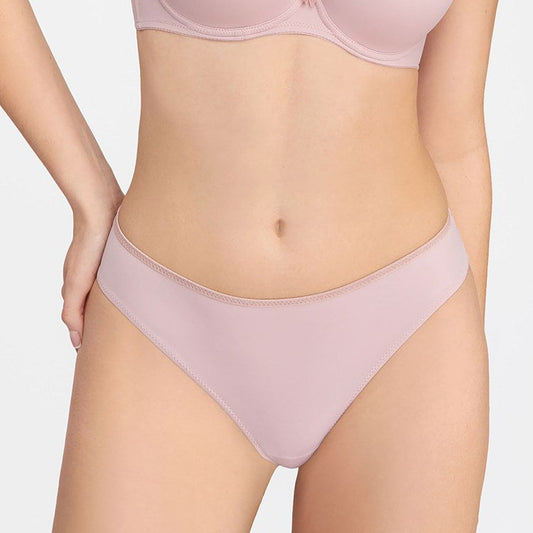 Person wearing a light pink bra and underwear set on a plain background